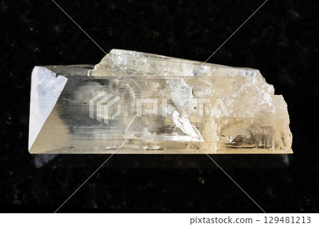 sample of raw danburite mineral on black granite 129481213