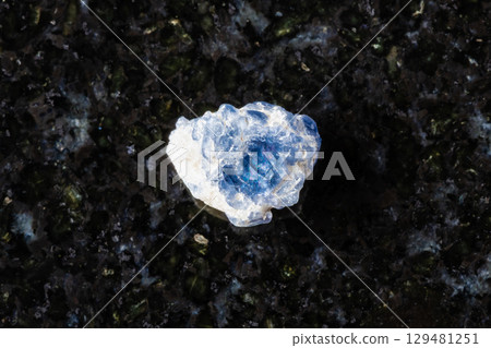 sample of raw blue spinel crystal on black granite 129481251