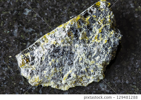 sample of raw diopside rock on black granite sample of raw diopside rock on black granite 129481288