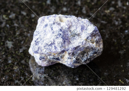 sample of raw cordierite rock on black granite sample of raw cordierite rock on black granite 129481292