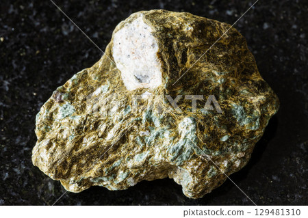 sample of rough lobanovite rock on black granite 129481310