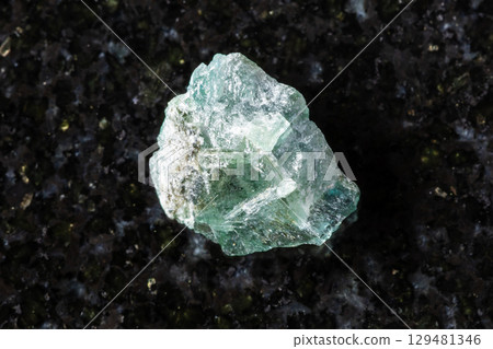 raw green alexandrite mineral in daylight on black 129481346