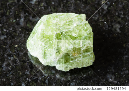 sample of rough diopside crystal on black granite sample of rough diopside crystal on black granite 129481394