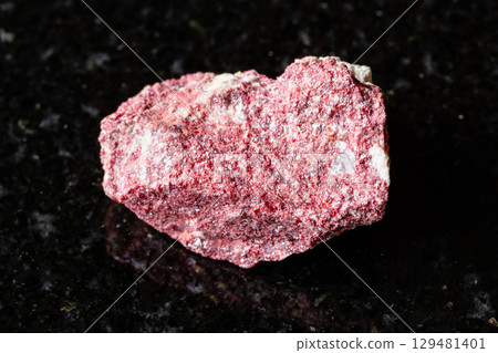 sample of rough cinnabar rock on black granite 129481401