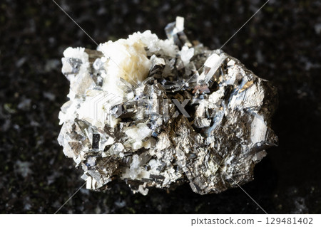 sample of rough arsenopyrite rock on black granite sample of rough arsenopyrite rock on black granite 129481402