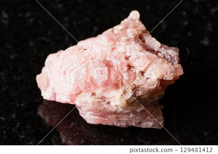 sample of rough rhodochrosite rock on black 129481412