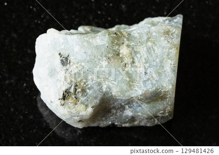 sample of raw gray labradorite mineral on black 129481426