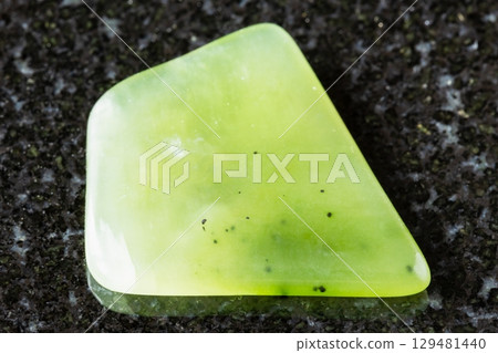 polished light green nephrite rock on black 129481440