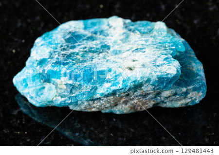 sample of uncut apatite rock on black granite sample of uncut apatite rock on black granite 129481443
