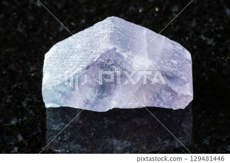 rough purple striped fluorite mineral on black 129481446