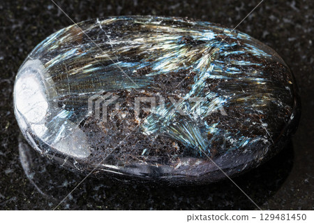 sample of polished nuummite rock on black granite sample of polished nuummite rock on black granite 129481450