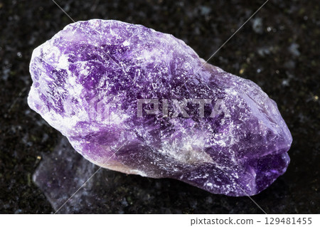 sample of uncut amethyst rock on black granite 129481455