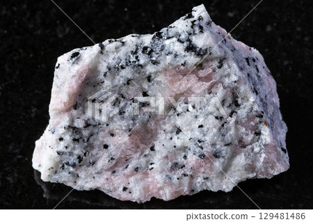 raw miaskite with pink cancrinite rock on black raw miaskite with pink cancrinite rock on black 129481486