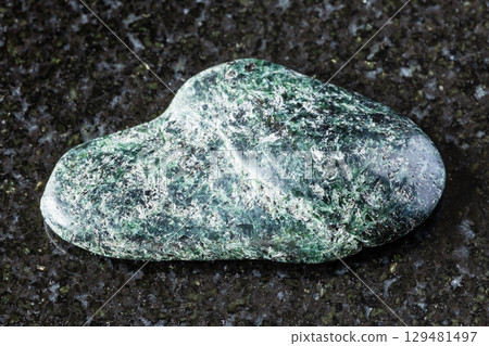 sample of polished actinolite rock on black 129481497