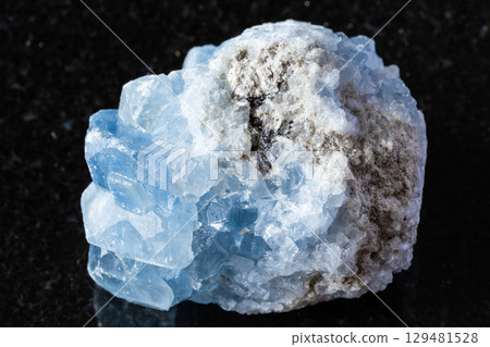 sample of raw celestite mineral on black granite 129481528