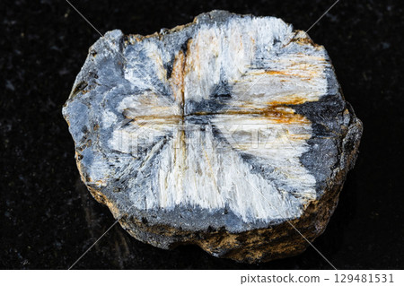 sample of raw chiastolite rock on black granite 129481531