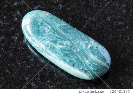 sample of polished chernomorite mineral on black 129481535