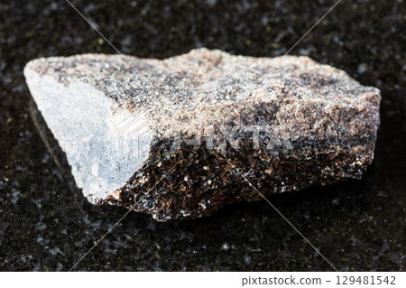 sample of raw phlogopite rock on black granite sample of raw phlogopite rock on black granite 129481542
