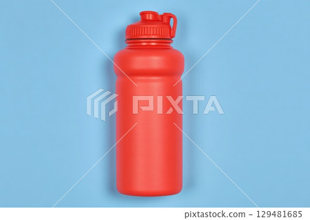 A bright red water bottle is centered on a light blue background, showcasing its smooth design and durable material, ideal for hiking, sports, and everyday hydration. A bright red water bottle is centered on a light blue background, showcasing its smooth design and durable material, ideal for hiking, sports, and everyday hydration. 129481685