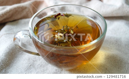 溫暖的自然光下熱氣騰騰的草藥茶的特寫 129481716