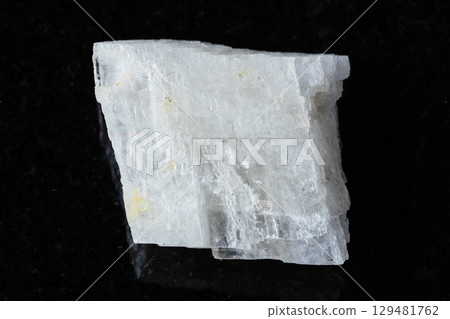 sample of rough colorless calcite mineral on black 129481762