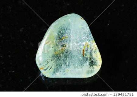 sample of tumbled blue topaz mineral on black 129481781