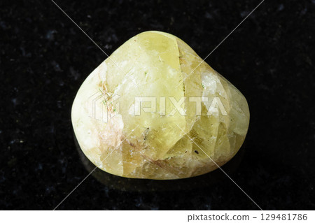 sample of tumbled saamite mineral on black granite sample of tumbled saamite mineral on black granite 129481786