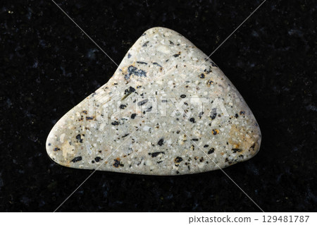 sample of polished andesite rock on black granite sample of polished andesite rock on black granite 129481787