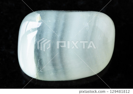 tumbled colorless calcite mineral on black 129481812