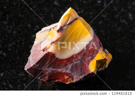 sample of raw colorful mookaite rock on black 129481818