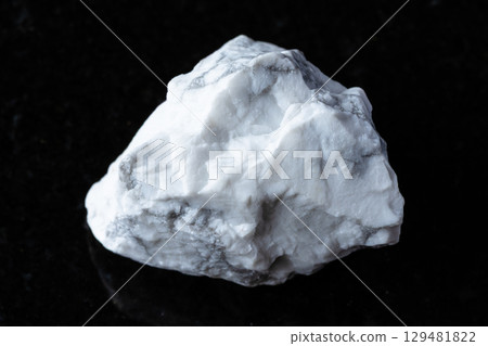 sample of raw howlite mineral on black granite 129481822