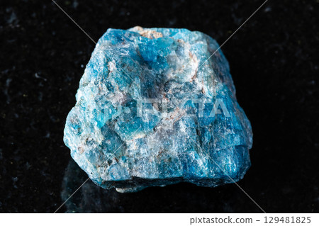 sample of rough blue apatite rock on black granite 129481825