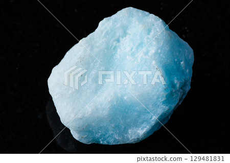 sample of raw blue aragonite rock on black granite 129481831