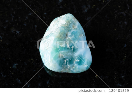 sample of rough larimar mineral on black granite 129481859