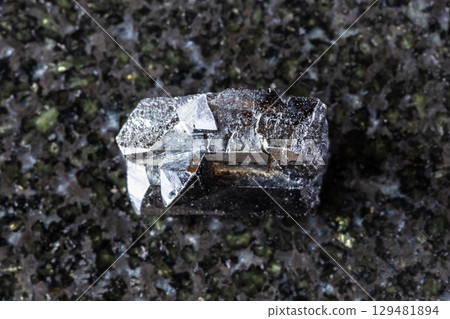 sample of rough ilvaite mineral on black granite 129481894