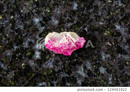 sample of rough pink ruby mineral on black granite sample of rough pink ruby mineral on black granite 129481922