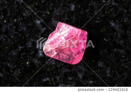 rough pink spinel crystal on black granite rough pink spinel crystal on black granite 129481928