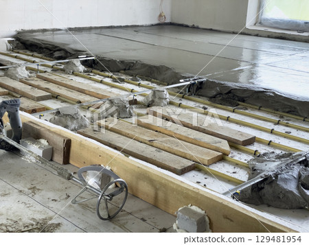 Warm floor heating installation process in room. Warm floor heating installation process in room. 129481954