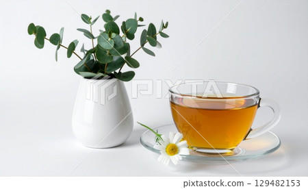 A relaxing moment with chamomile tea and small vases of eucalyptus 129482153