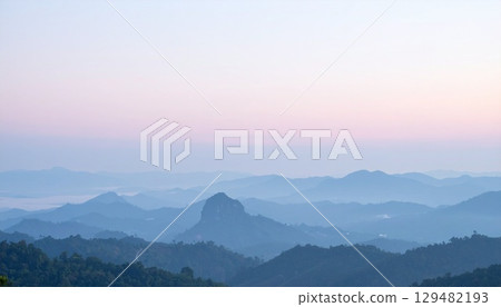 Gentle mountains shrouded in morning mist and pale pastel skies 129482193