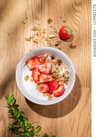 Granola or muesli with natural greek yogurt, strawberry in a bowl on a wooden background Granola or muesli with natural greek yogurt, strawberry in a bowl on a wooden background 129482278