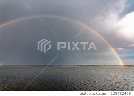 Rainbow over Blue lake with cloudy sky Rainbow over Blue lake with cloudy sky 129482438