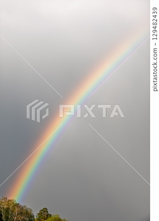 Rainbow over Blue lake with cloudy sky 129482439