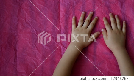 Top view closeup child hands on pink background with copy space Top view closeup child hands on pink background with copy space 129482681
