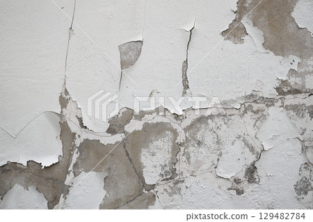 Close up of old stucco cracks on the wall, Old cracked paint on the concrete wall, Weathered paint cracks on plaster. Cracked wall background. Close up of old stucco cracks on the wall, Old cracked paint on the concrete wall, Weathered paint cracks on plaster. Cracked wall background. 129482784