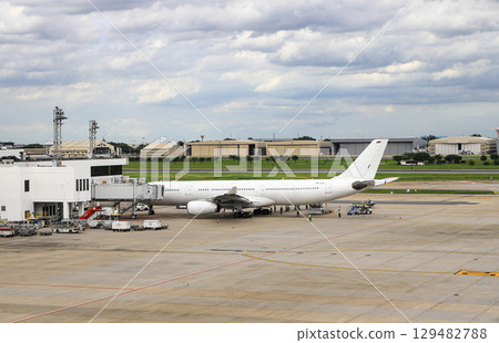 Don-Mueang Airport view, Airplane parking at passenger gate, connect to gate with jet bridge. Being service by ground service team. 129482788