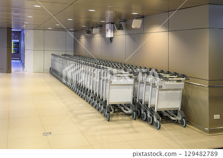 Row of airport trolleys get ready to serve passengers at Airport terminal. Row of airport trolleys get ready to serve passengers at Airport terminal. 129482789