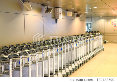 Row of airport trolleys get ready to serve passengers at Airport terminal. Row of airport trolleys get ready to serve passengers at Airport terminal. 129482790