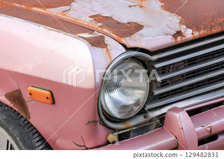 The car headlights of abandoned old rusty car on the side of the road. The car headlights of abandoned old rusty car on the side of the road. 129482831