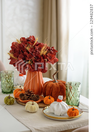 Thanksgiving table setting with decorative pumpkins, candles and string lights on white wooden table Thanksgiving table setting with decorative pumpkins, candles and string lights on white wooden table 129482837